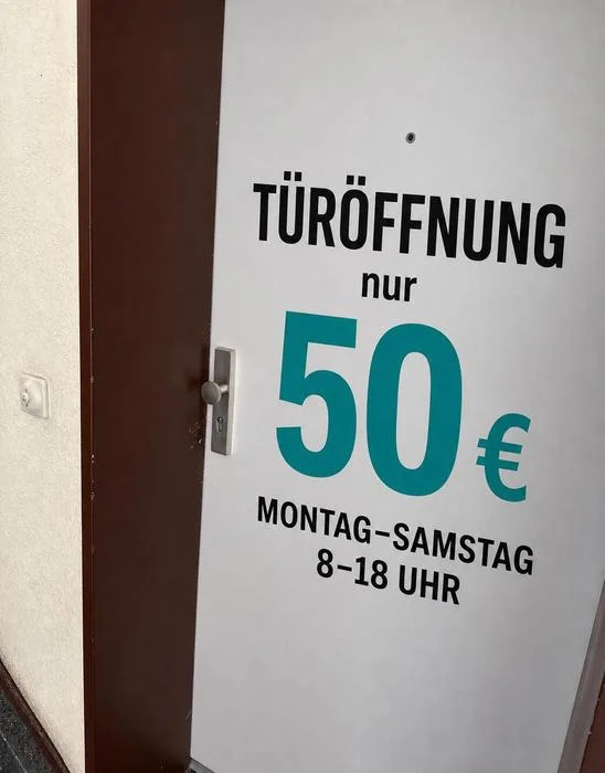 Wohnungstür mit der Aufschrift: Türöffnung nur 50 Euro, Montag bis Samstag, 8 bis 18 Uhr