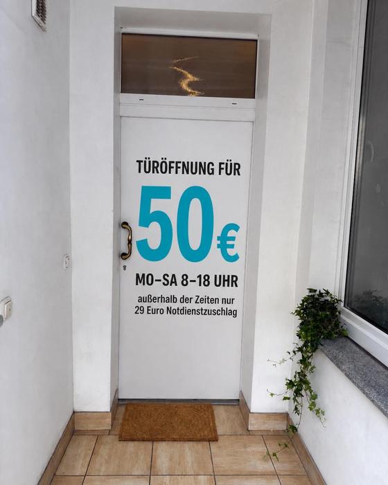 Schlüsseldienst Bergisch Gladbach: Haustür mit Preisschild Festpreis-Türöffnung 50 €, Mo–Sa 8–18 Uhr