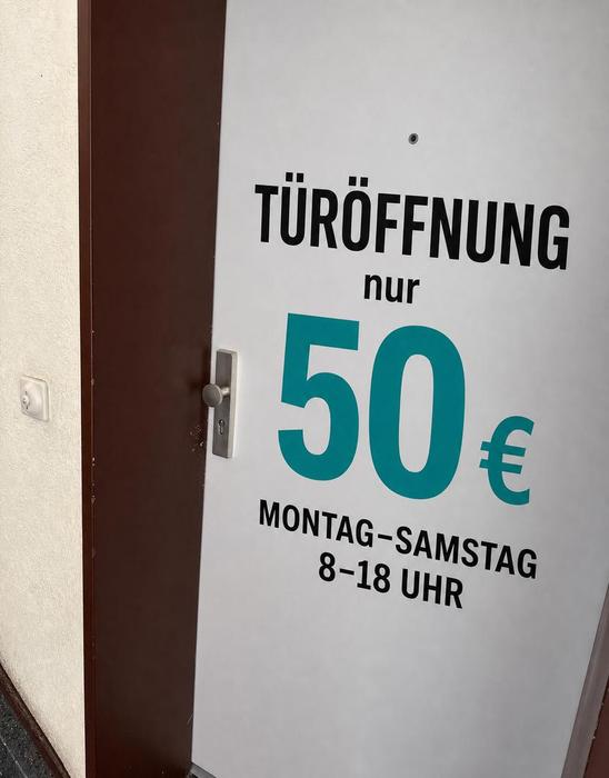 Schlüsseldienst Bergisch Gladbach: Preisschild Festpreis-Türöffnung 50 € an einer geöffneten Wohnungstür